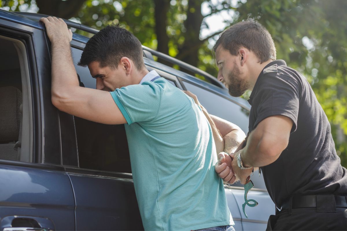 A police officer arrests a man.