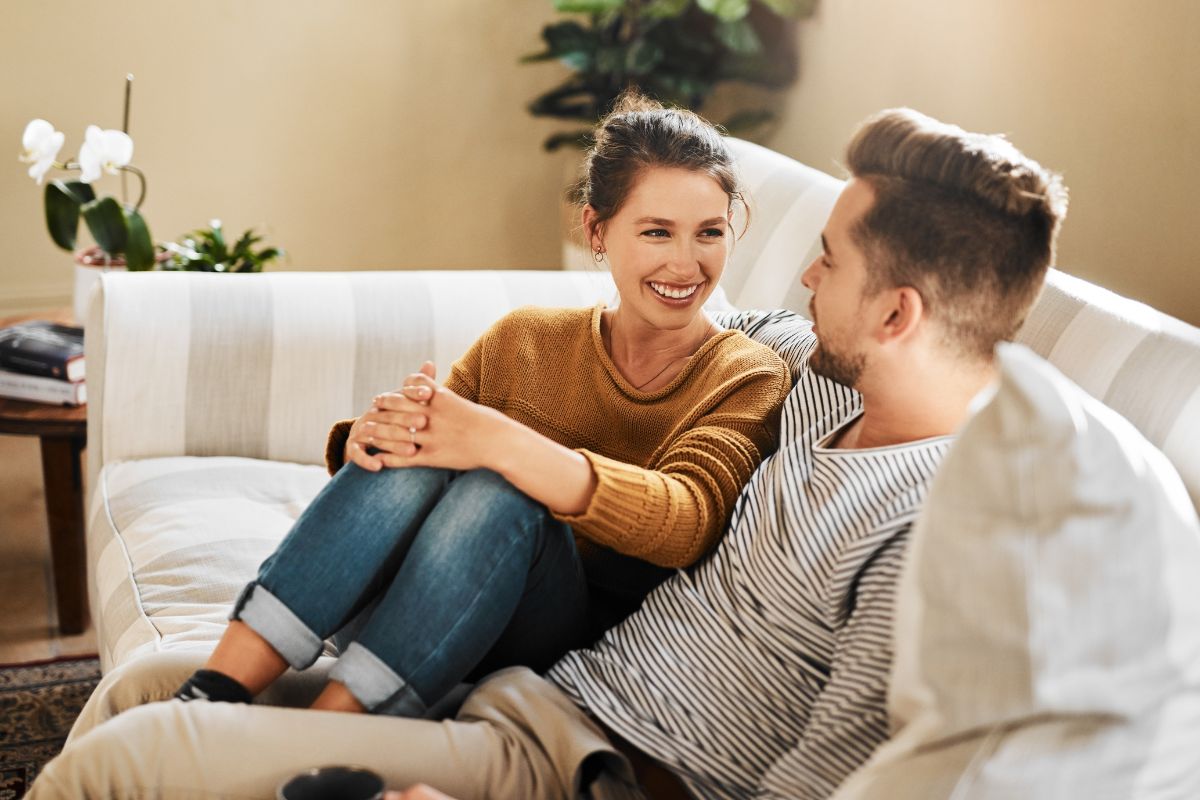 Two people sitting closely on a couch.