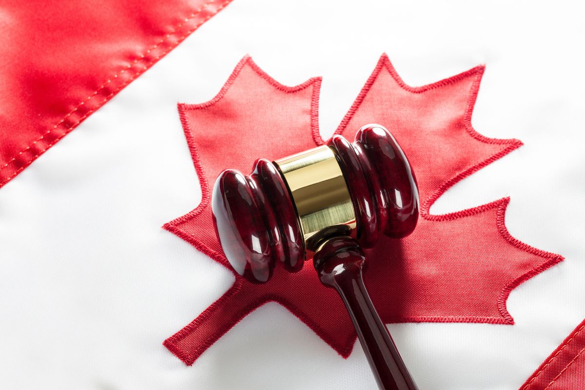 A judge's gavel resting on a Canadian flag.