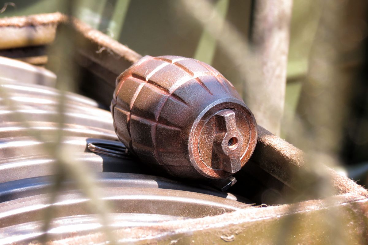 A hand grenade placed on a metal surface.