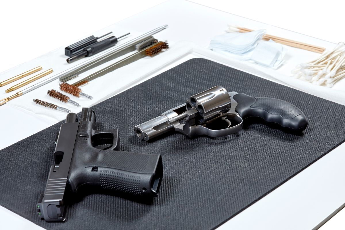 Two handguns placed on a black mat.
