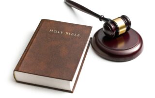 Holy Bible next to a wooden judge’s gavel.