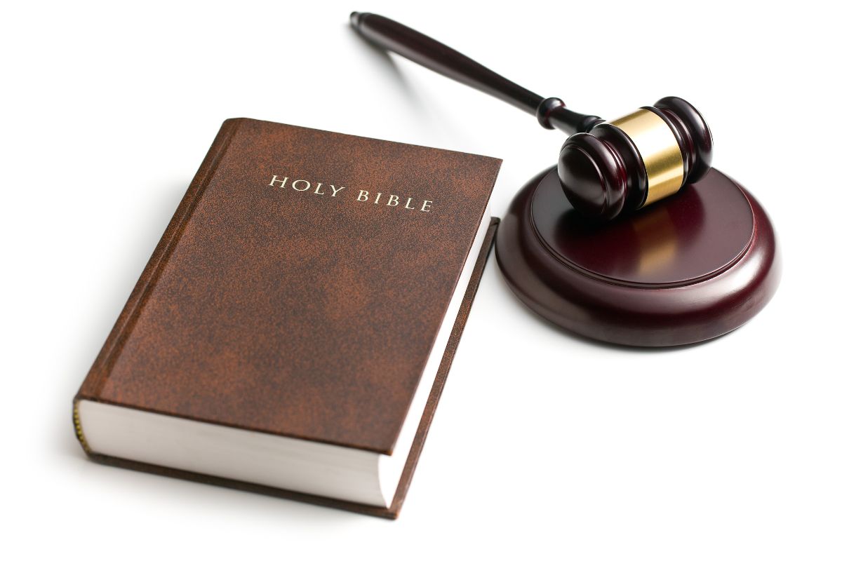 Holy Bible next to a wooden judge’s gavel.