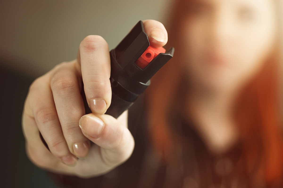 A woman holding pepper spray.