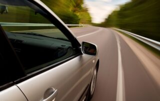 A car speeding on a highway, appearing to flee from a situation.