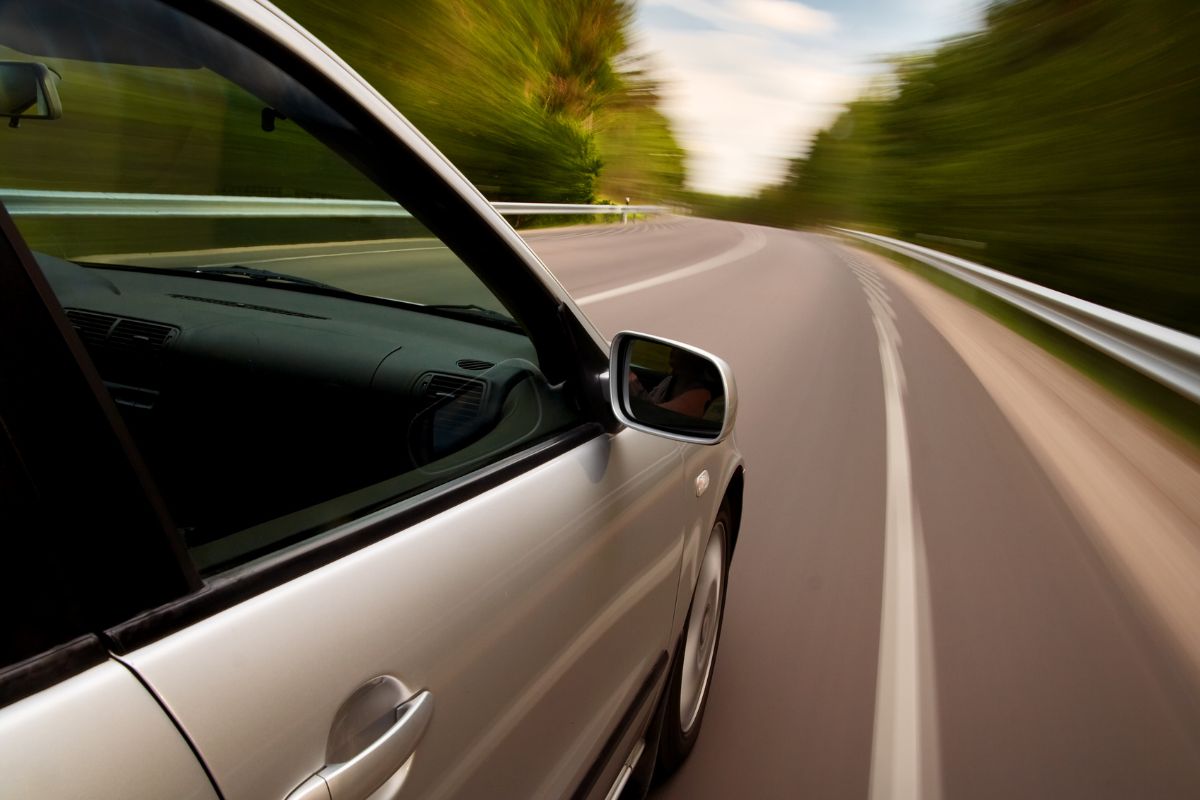 A car speeding on a highway, appearing to flee from a situation.