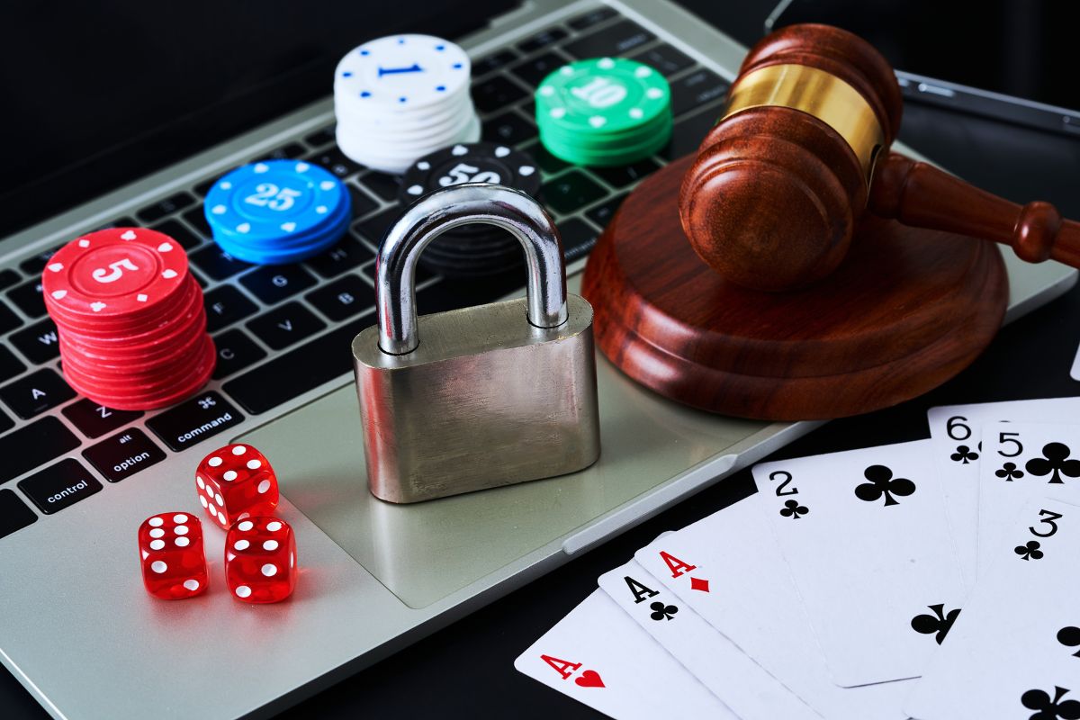 Gambling chips, cards, a gavel, and a laptop.