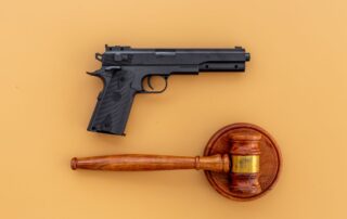 Handgun, weapon, and a judge's gavel.