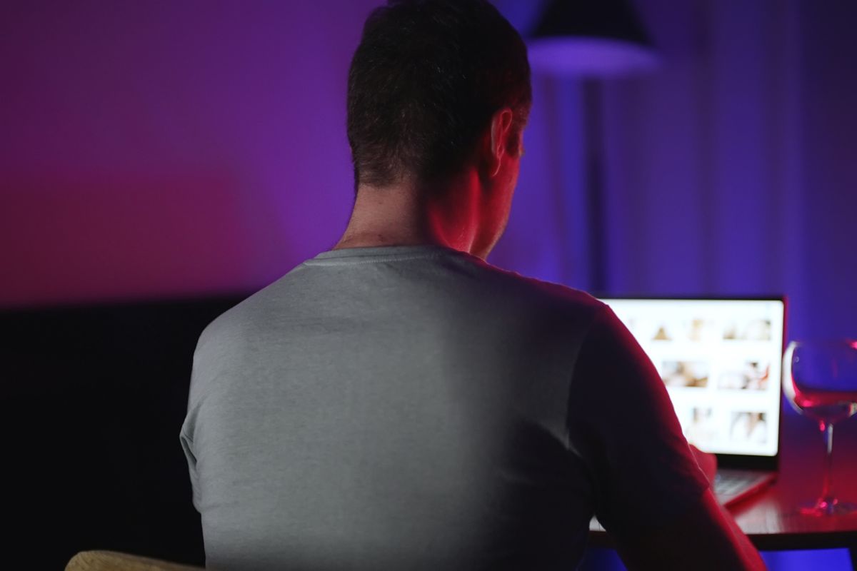 A man is viewing explicit content on a laptop.