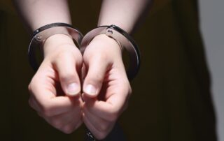 Close-up of a person's hands in handcuffs.