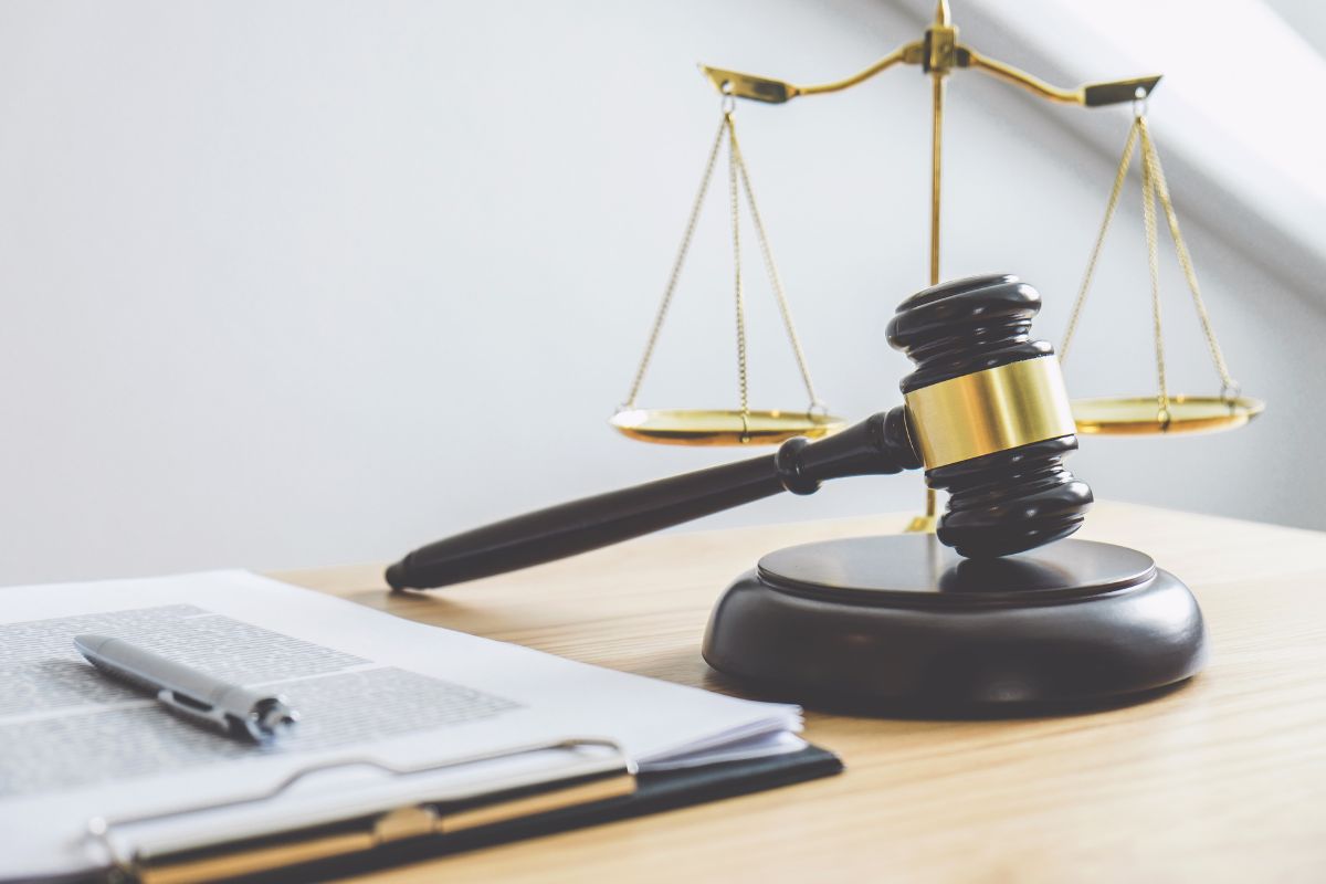 Gavel, scales of justice, and legal documents on a desk.