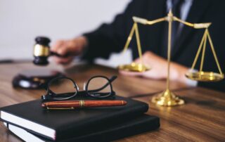 A judge's gavel, law books, glasses, and scales of justice.