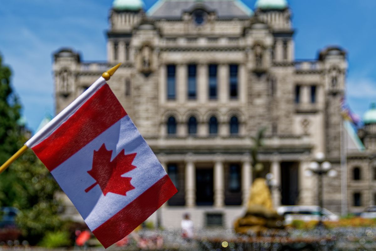 Canadian flag in front of a courthouse building.