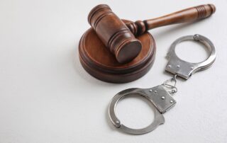 Judge’s gavel beside handcuffs.