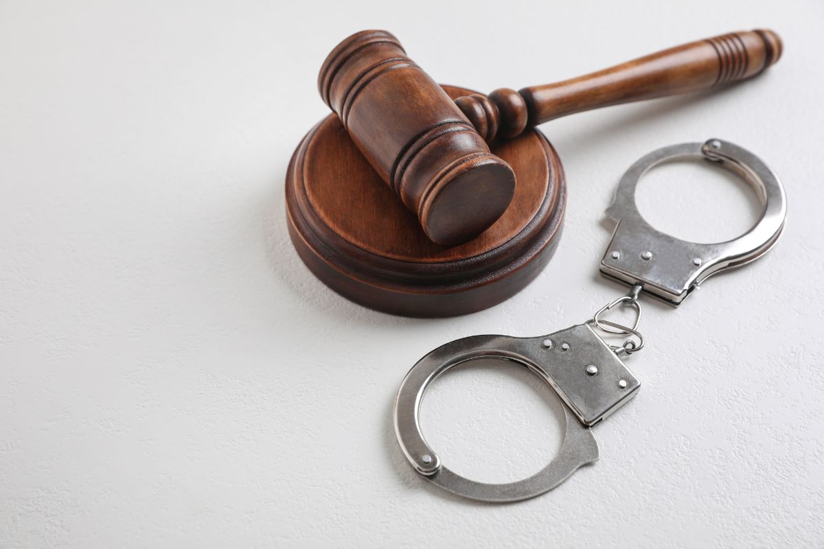 Judge’s gavel beside handcuffs.