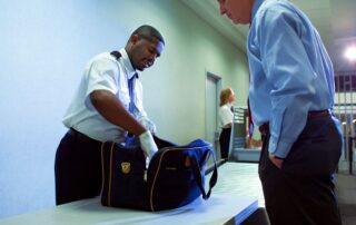 Border officer checking a traveler’s bag.