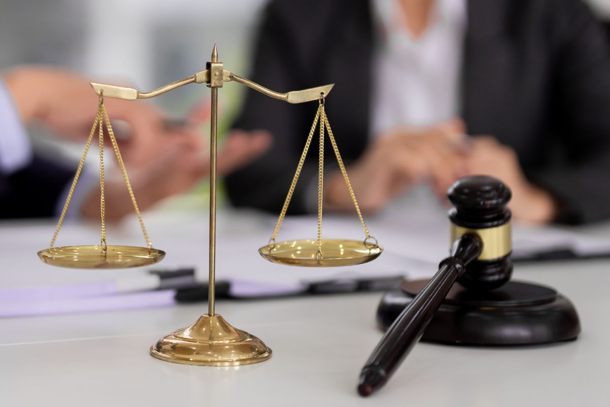Scales of justice and gavel in courtroom setting. Scales of justice and gavel in courtroom setting.