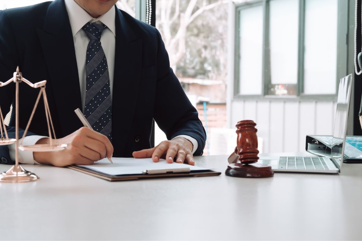 Lawyer writing notes at a desk.