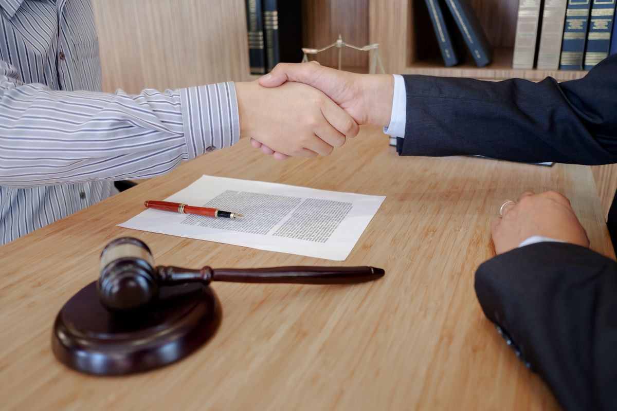 Client and lawyer shaking hands during a legal consultation. Client and lawyer shaking hands during a legal consultation.
