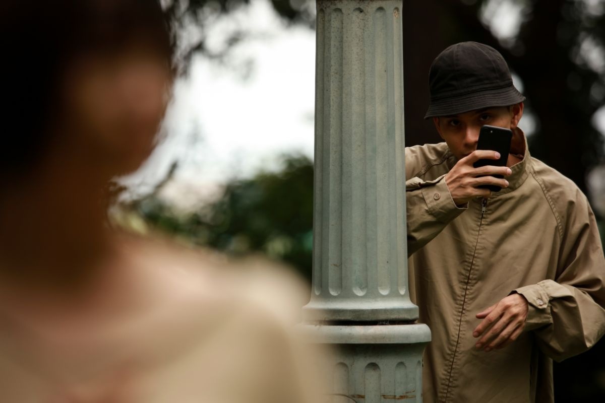 Man secretly recording someone with a phone. Man secretly recording someone with a phone.