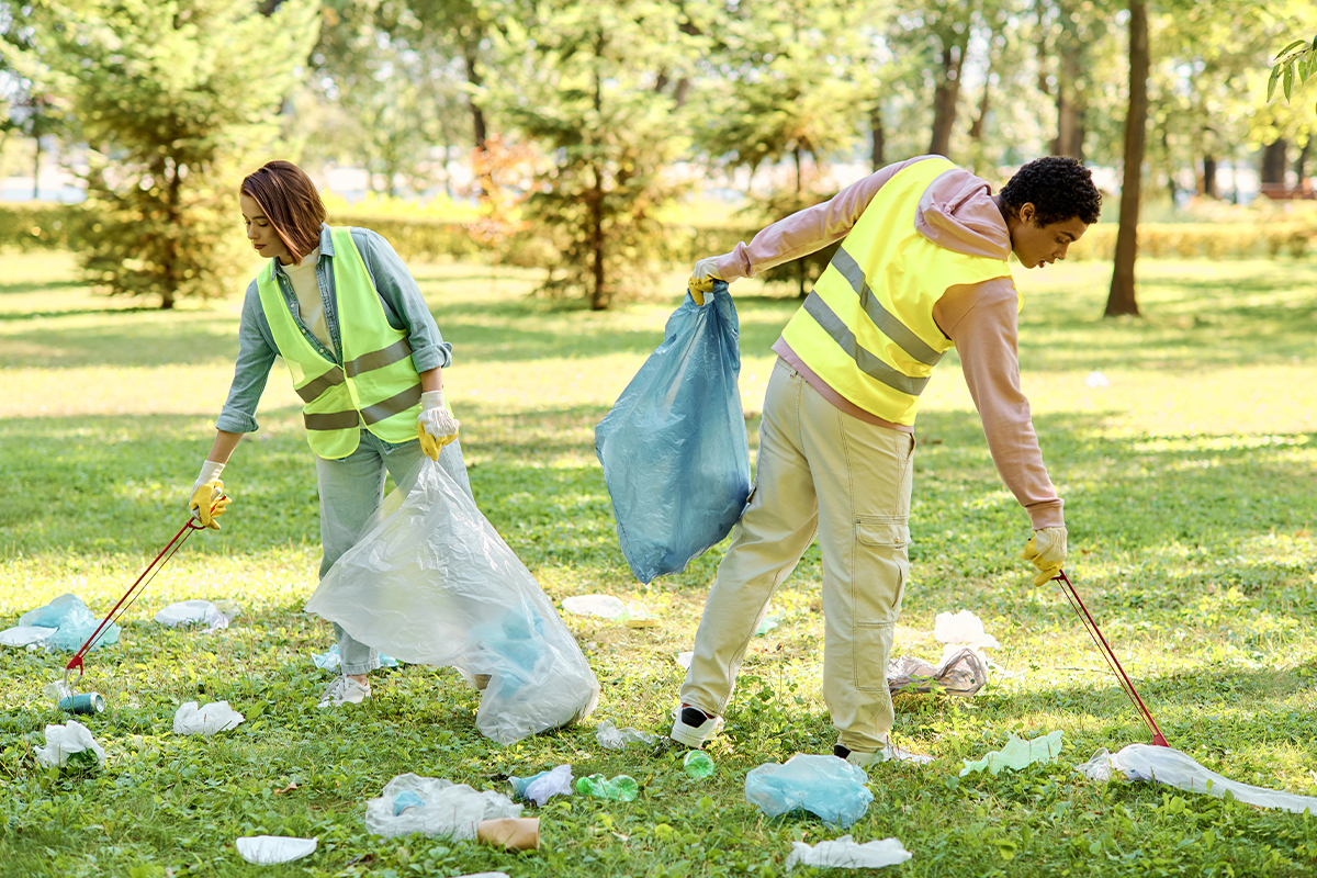 Two people in the park picking up trash as community service