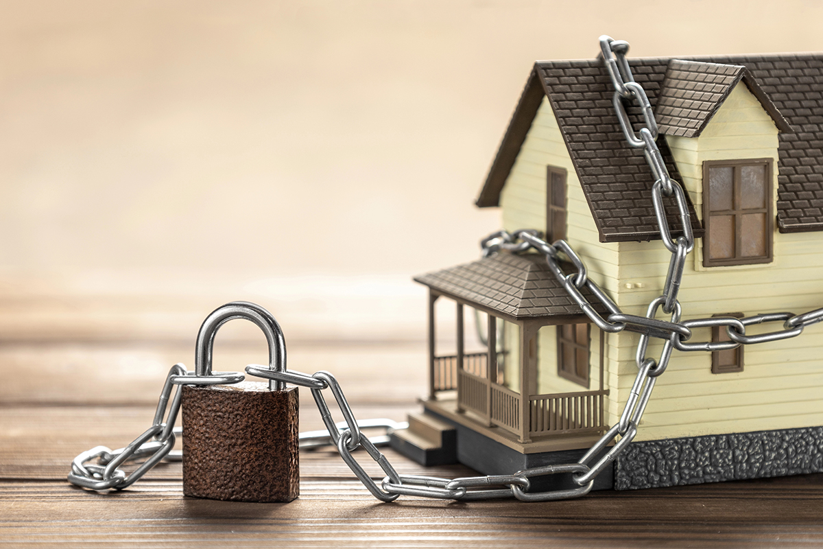 A house wrapped in chains representing house arrest