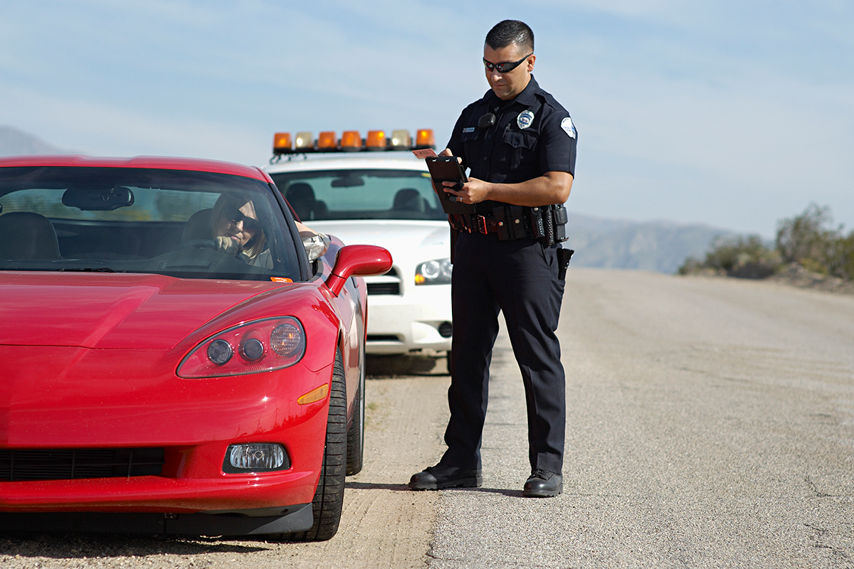 A police officer issues a ticket to a speeding driver