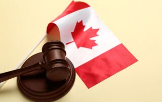 Judge’s gavel beside a Canadian flag on a desk.