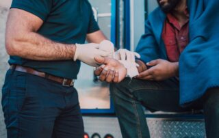 Paramedic treating a man’s injured wrist.
