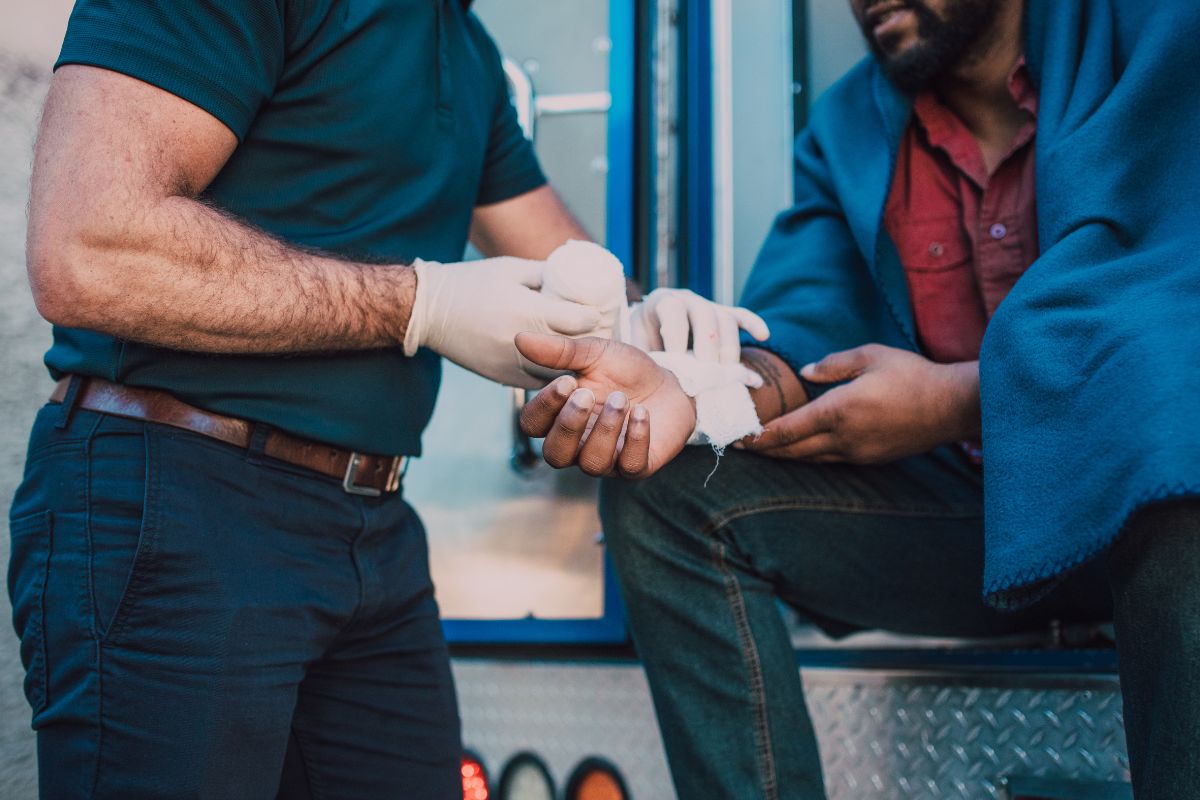 Paramedic treating a man’s injured wrist. Paramedic treating a man’s injured wrist.