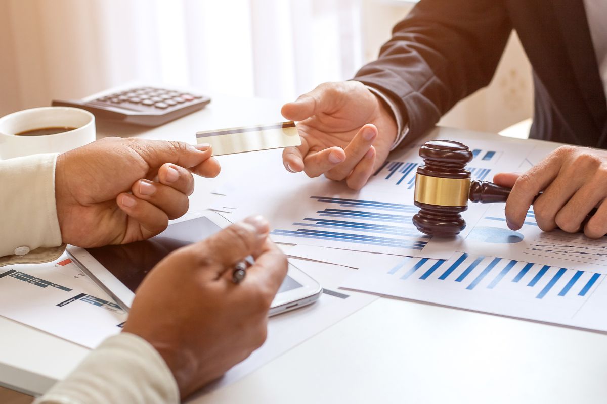 Two people discussing financial documents at a desk. Two people discussing financial documents at a desk.
