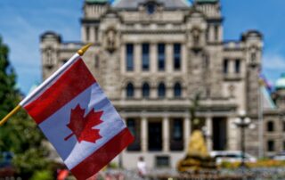 Canadian flag in front of a courthouse building.