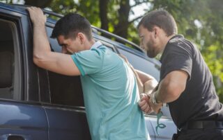 A police officer arrests a man.