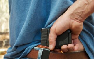 A man concealing a handgun.
