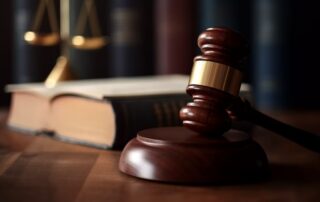 Judge’s gavel beside legal books and scales of justice.