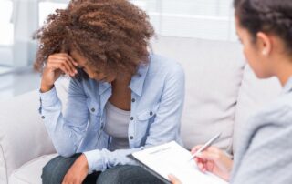 Woman sitting on sofa and crying.