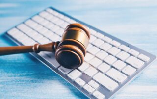 A judge’s gavel placed on a computer keyboard.