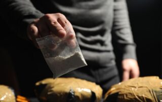 Man holding plastic bag with cocaine.