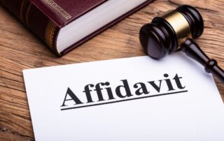 A paper labeled “Affidavit” next to a gavel and a law book on a desk.