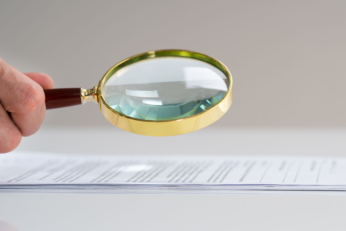 Fraud auditor using magnify glass. Fraud auditor using magnify glass.