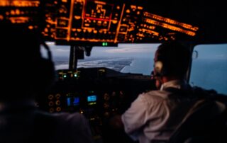 Airplane cockpit view with two pilots.