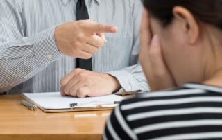 Man pointing aggressively at a distressed woman during a tense conversation.