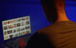 Man viewing explicit content on a laptop.