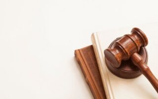 A judge’s wooden gavel resting on two law books.