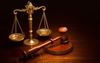A wooden gavel and golden scales of justice.