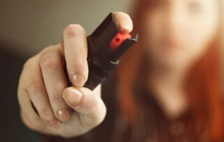 A woman holding pepper spray.
