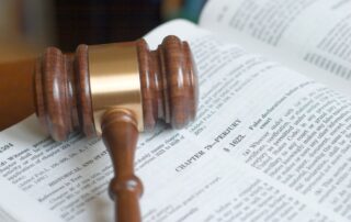 Close-up of a judge’s gavel resting on an open law book.
