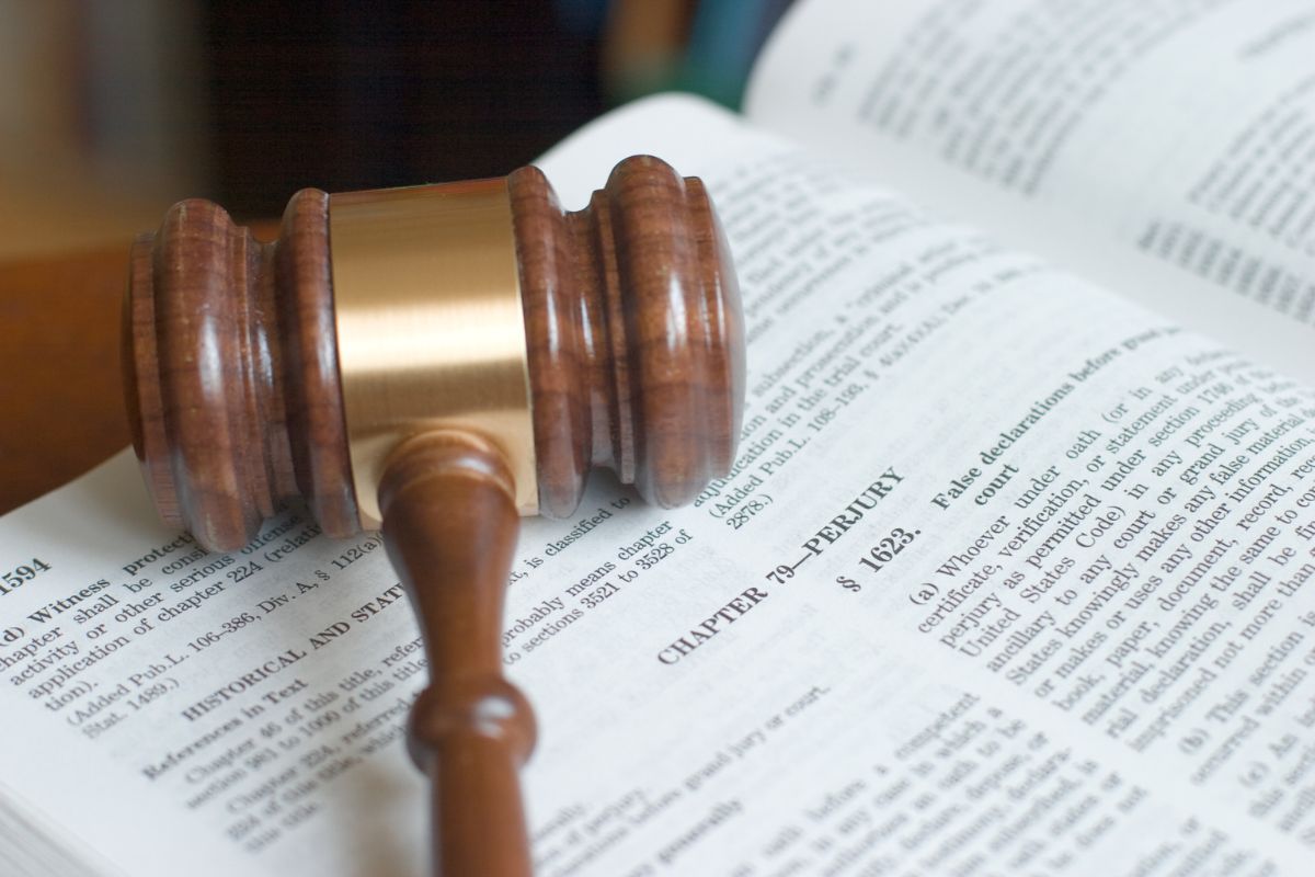 Close-up of a judge’s gavel resting on an open law book. Close-up of a judge’s gavel resting on an open law book.