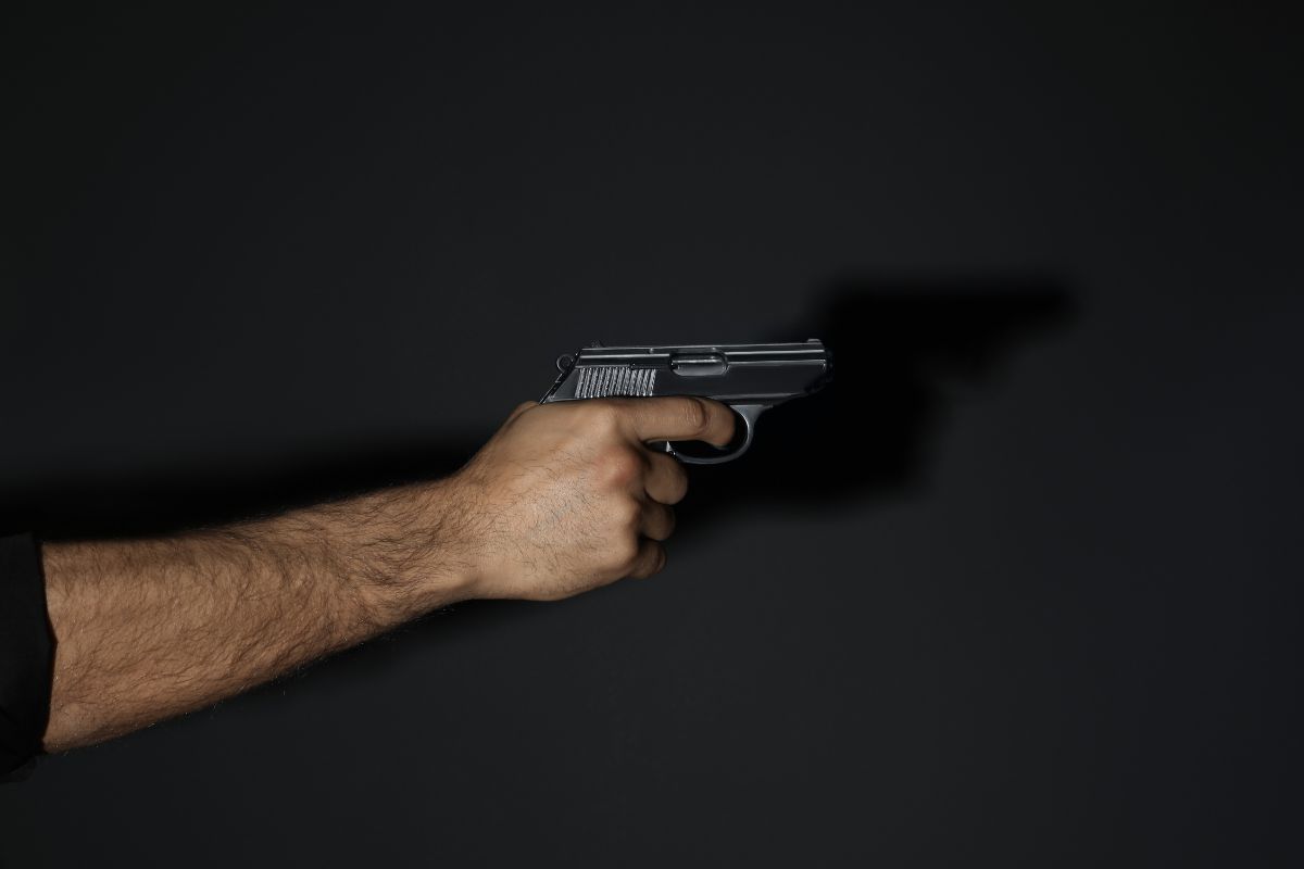 Holding and pointing a pistol. Holding and pointing a pistol.