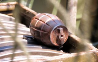 A hand grenade placed on a metal surface.